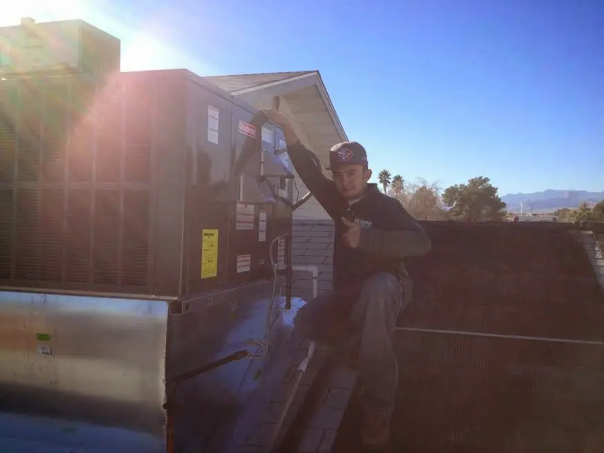 HVAC technician performing AC Tune-Up on a rooftop unit in Westport